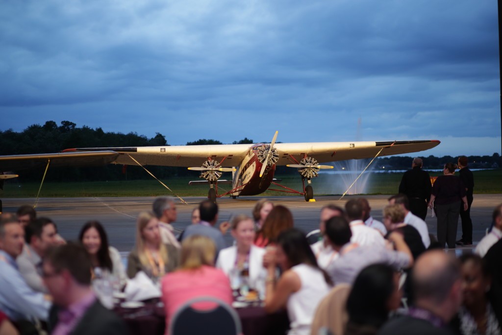 employees of holiday party outside with vintage aircraft in background