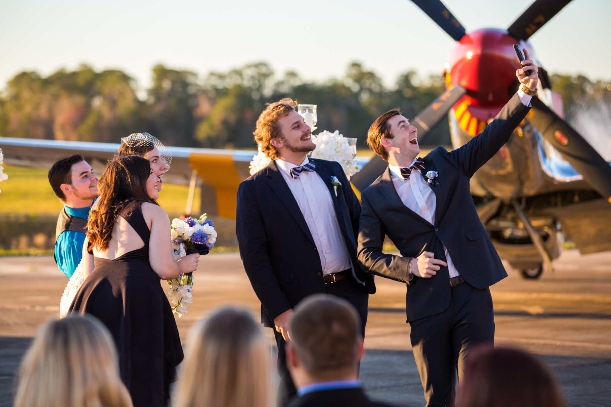 groom and best man selfie with p51 mustang in background